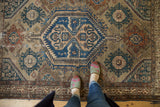 Distressed Malayer rug with navy blue hexagonal medallion, sand field, and terracotta palmettes.