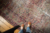 Antique Kerman carpet detail with scrolling arabesques, cochineal red, navy, ivory, and aged patina.