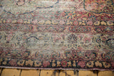 Traditional Persian Kerman border, cochineal red and navy floral arabesques, aged texture.