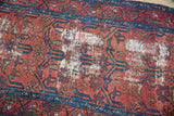 Hand-knotted Persian Lilihan rug with germinating plant motif and visible hard wear.