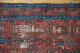 Close-up of the vintage Lilihan rug with rose and blue plant motifs, revealing wear and foundation.