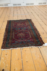Vintage Lilihan rug corner with dark raspberry red, sapphire blue border, and tattered fringe.