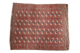 Vintage Bokhara carpet with intricate repeating gul motifs, dusty raspberry, navy, ivory.