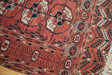 Vintage Bokhara rug detail: geometric guls, ornate borders, and fringe in raspberry, navy, ivory.