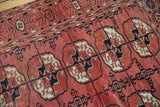 Intricate weave of repeating stylized gul motifs in dusty raspberry, navy black, and ivory.