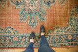 Distressed Oushak rug with Rococo border design in dusty tangerine, royal blue, and ivory.