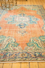 Distressed Oushak carpet corner with Rococo motifs, highlighting vibrant orange, royal blue, and teal green.