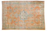 Distressed hand-knotted Oushak rug with tangerine orange field and blue floral medallion.