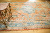 Distressed orange Oushak rug texture, showing worn knot heads and a blue border.