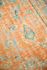 Textured, distressed orange Oushak pile revealing blue, teal, and ivory motifs.
