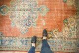 Distressed vintage Oushak rug, highlighting scalloped medallion with Rococo details and tangerine field.