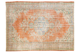 Distressed Oushak carpet with burnt orange, faded blue, and sand rococo floral design.