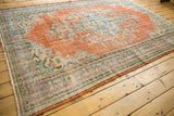 Distressed vintage Oushak carpet side showing textured burnt orange field and Rococo blue border patterns.