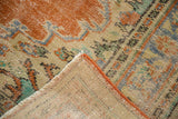 Distressed vintage Oushak rug corner displays hand-knotted back and secure orange selvage.