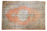 Distressed vintage Oushak rug with a tangerine field, geometric medallion, and serrated borders.