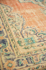 Distressed serrated border design of vintage Oushak carpet, showing dusty tangerine, teal, and ivory.