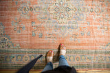 Distressed vintage Oushak rug with faded peach, blue, and mint European floral motifs.