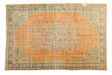 Distressed vintage Oushak rug with faded tangerine, blue geometric medallion, and worn pile, 6'4