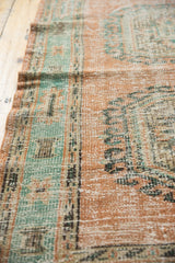 Distressed vintage Oushak rug detail, showing pale blush and mint green with worn pile.