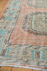 Textured vintage Oushak pile in pale blush and mint, highlighting worn rams horn motif.
