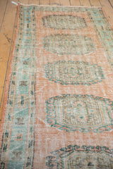 Pale blush Oushak runner with mint green rams horn medallion and distressed texture.