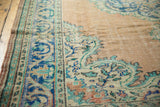 Distressed Oushak rug's meandering vine border, scalloped contour, in aqua, blue, and beige hues.
