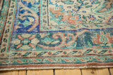 Distressed vintage Oushak rug border detail, featuring meandering vines in aqua, rose, and beige.