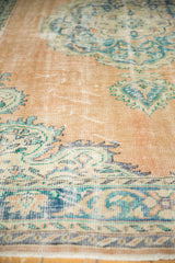 Distressed Oushak rug showing low pile texture, faint foundation, and faded aqua blue details.