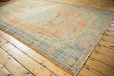 Distressed Oushak carpet with sunned tangerine field and faded royal blue motifs.