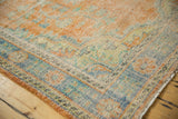 Faded tangerine and royal blue floral motifs on a distressed vintage Oushak rug pile.