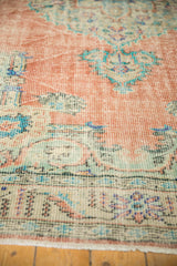 Decorative distressed Oushak pile with terracotta and mint green, highlighting even wear.