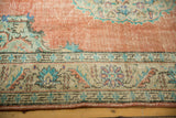 Distressed dusty rose field, showing even wear and a traditional lotus border.