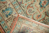 Folded vintage Oushak rug corner showing distressed pile, terracotta selvage, and hand-knotted reverse.