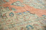 Distressed vintage Oushak rug close-up showing even wear, terracotta, mint green, and blue patterns.