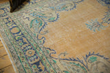 Distressed pale apricot Oushak field with faint foundation, showing Rococo stylized border.