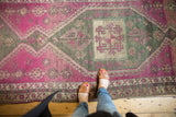 Distressed Oushak runner featuring geometric medallion in vibrant purple and charcoal tones.