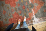 Distressed vintage Oushak runner, madder red and time-softened silver geometric pattern with visible foundation wear.