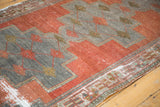 Distressed Oushak runner with rectilinear vinery, madder red, oxidized silver, and green border.
