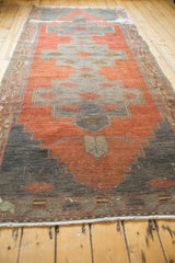 Distressed vintage Oushak runner edge featuring madder red, oxidized silver, and pistachio geometric details.