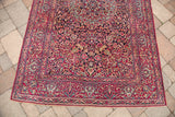 Finely woven deep purple field and intricate red floral borders on a vintage Isfahan rug corner.