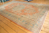 Distressed hand-knotted Turkish Oushak rug, with vivid terracotta and blue-green border.