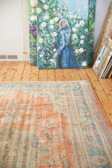 Distressed pile of Oushak rug showing faded pale terracotta and ocean blue-green colors.