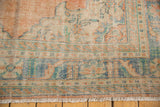 Distressed vintage Oushak carpet corner, pale terracotta, ocean blue-green, ivory, and fringe.