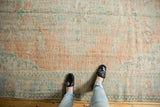 Distressed vintage Oushak rug, faded tangerine, ivory, mint green, and blue European motifs.
