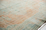 Distressed Oushak rug pile showing faded ivory, tangerine, mint green, and pale blue.
