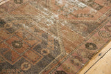 Distressed Oushak rug detail: blush, rose, and charcoal pattern with areas of foundation.