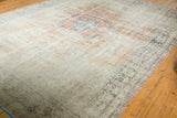 Distressed Oushak rug corner, highlighting faded blue border and worn texture.