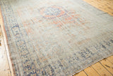Distressed vintage Oushak rug with soft rose blush and denim blue patterned texture.