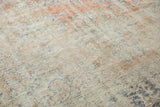 Distressed vintage Oushak rug texture revealing even wear, with faded rose blush and blue motifs.