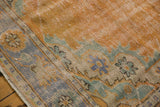 Distressed Oushak rug edge, faded tangerine orange field, blue and mint green border.